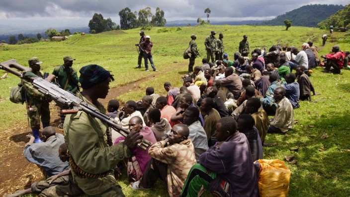 Congolese soldiers guard suspected M23 rebel fighters who surrendered in Chanzo village in the Rutshuru territory near the eastern town of Goma
