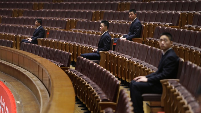 Security personnel sit inside the Great Hall of the People in Beijing