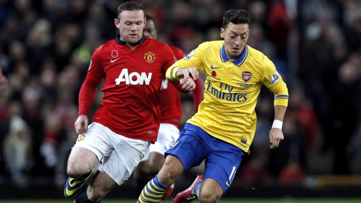 Manchester United's Rooney chases Arsenal's Ozil during their English Premier League soccer match in Manchester