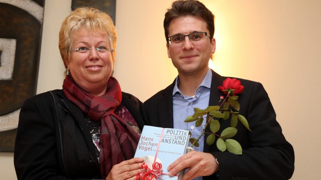 SPD Dachau: "Unter diesen Umständen kandidiere ich wieder": Christa Keimerl gratuliert Florian Hartmann mit einem Buch und einer Rose zur OB-Kandidatur.