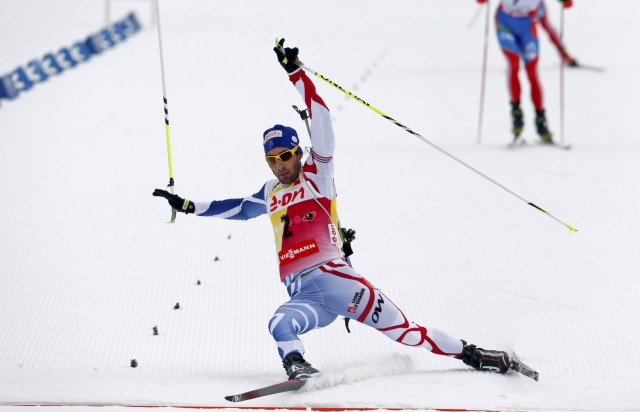 Fourcade of France falls as he leans to touch the finish line in the men's 12.5 km pursuit during the International Biathlon Union World Championships in Nove Mesto