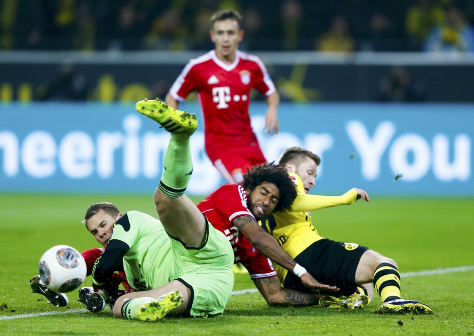 Bayern Munich's Neuer makes a save as Borussia Dortmund's Blaszczykowski collides with Dante during their German first disvison Bundesliga soccer match in Dortmund