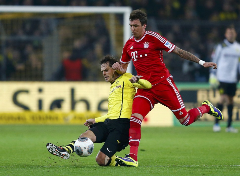 Borussia Dortmund's Friedrich challenges Bayern Munich's Mandzikic during their German first disvison Bundesliga soccer match in Dortmund