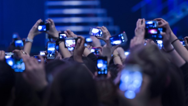 Jugendliche Fans halten Fotohandys beim Konzert
