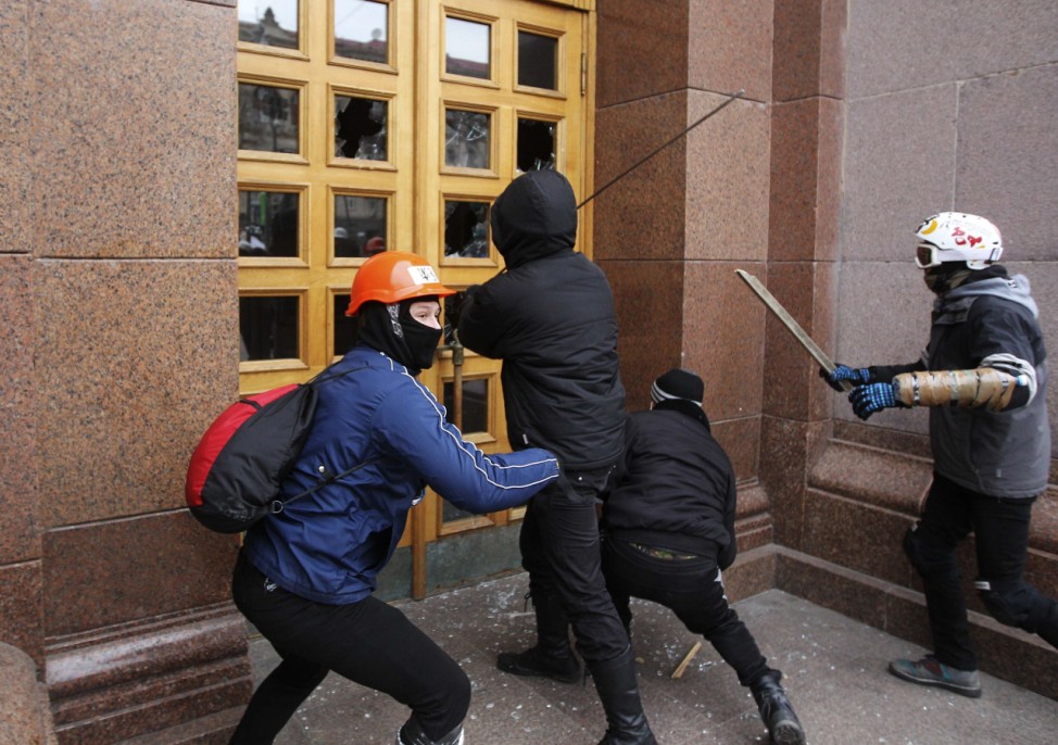 Unidentified men break the door of the Kiev City State Administration (Kiev City Council) building during a rally held by supporters of EU integration in Kiev
