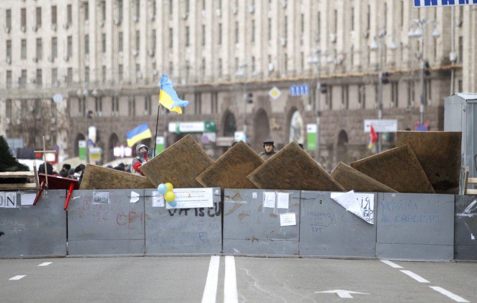 Protesters are seen near barricades which blocked the main avenue in Kiev