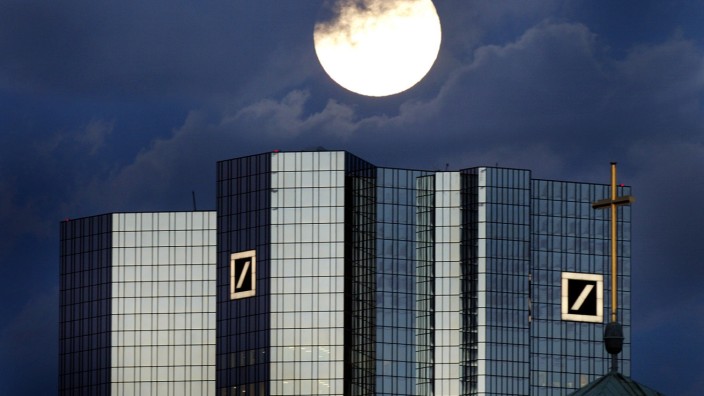 A rising full moon is seen over the twin towers of Germany's Deutsche Bank headquarters in Frankfurt