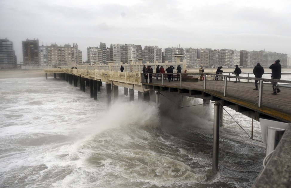 Waves crash against a bridge over the North Sea in Blankenberge