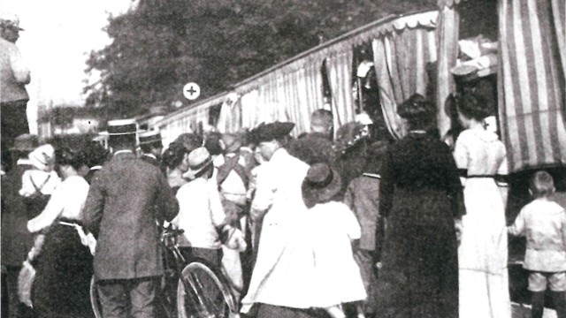 München im Ersten Weltkrieg: Neugierige drängen sich im September 1914 um einen Trambahn-Lazarettwagen mit Verwundeten.