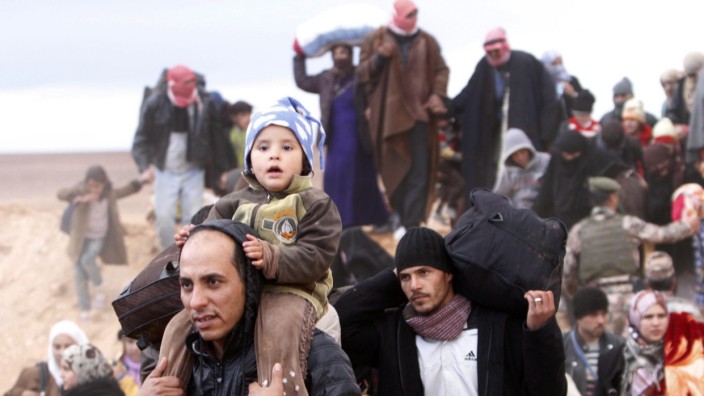 Syrian refugees arrive at a Jordan border town