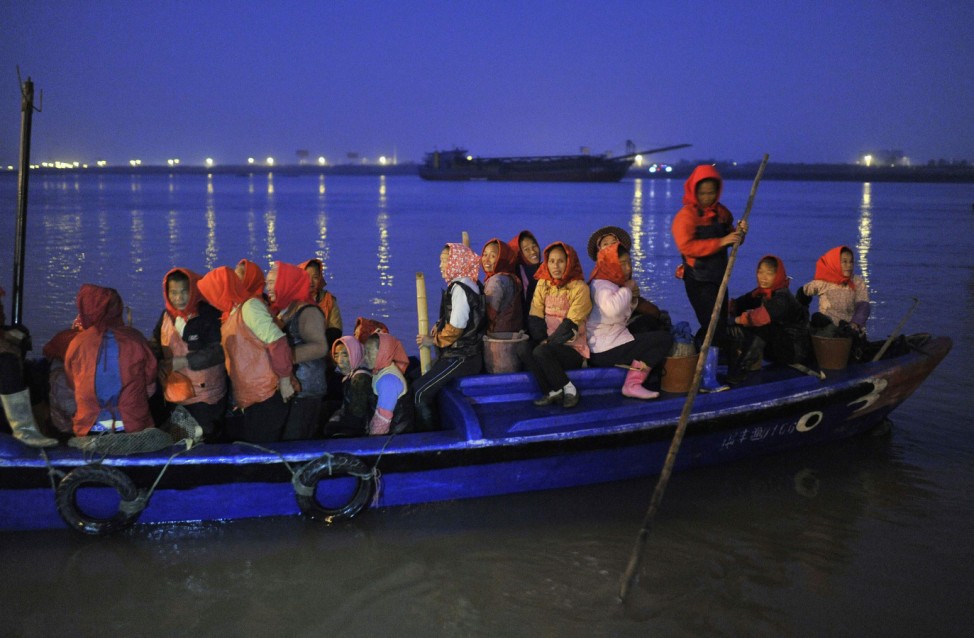 Villagers setting out to collect oysters, depart from a pier in early morning at Xunpu village in Quanzhou, Fujian province
