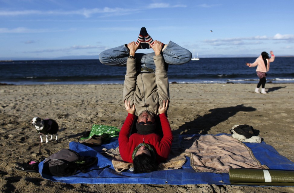 Ludwig and Beck practice acroyoga during the 'True Grit!' beach burn in Monterey