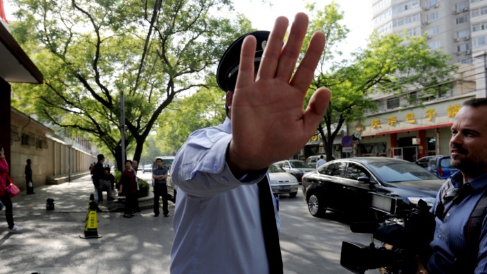 Pressefreiheit in China: Kein Durchgang für Berichterstatter: Ein chinesischer Polizist hält ausländische Reporter auf.