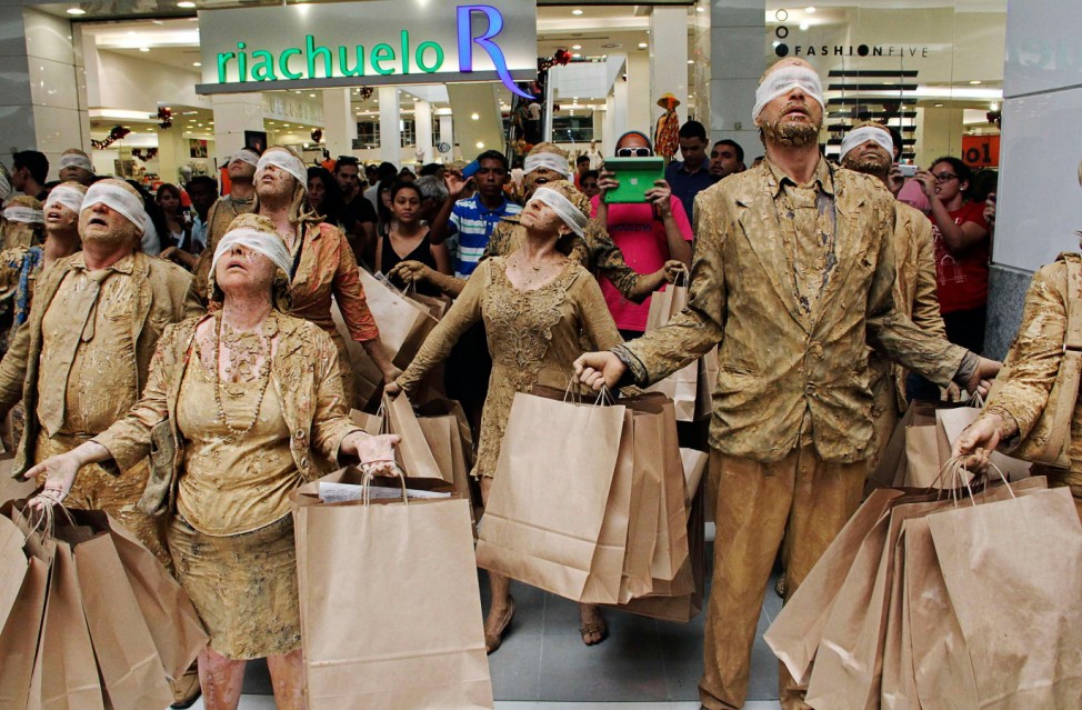 Students from the School of Communication and Art of the University of Sao Paulo perform a skit titled 'Blind Ones' as a protest against consumerism inside a shopping mall of Natal