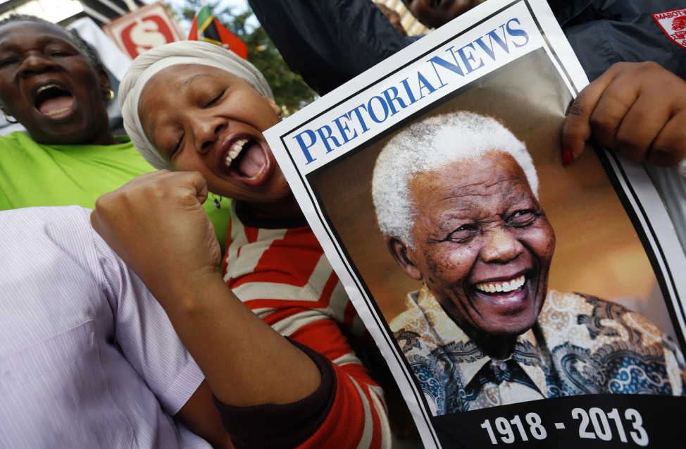 People cheer as the hearse carrying the coffin of former South African President Nelson Mandela travels through a street in Pretoria