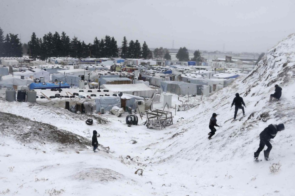 Syrian refugees play with snow during a winter storm in Zahle town, in the Bekaa Valley