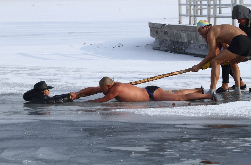 Winter swimmers try to pull man out of icy waters after he was trapped in partially frozen lake at a park in Changchun