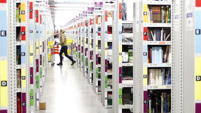 Worker collects items to pack into boxes at Amazon's logistics centre in Graben