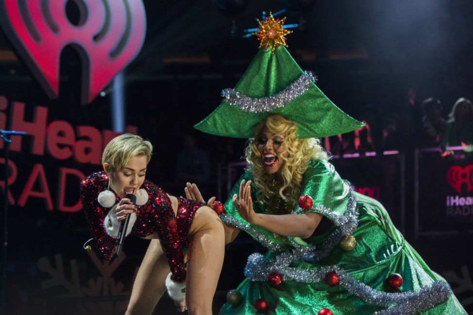 Singer Miley Cyrus 'twerks' a performer dressed as a Christmas tree as she performs during the 2013 Z100 Jingle Ball in New York