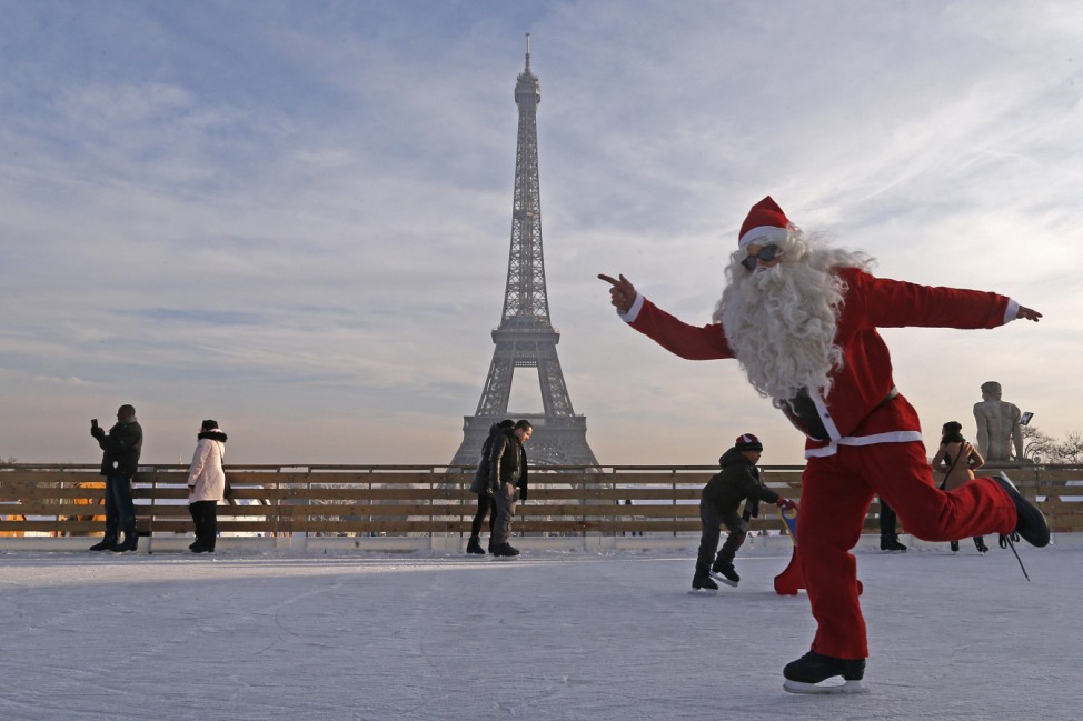 A man dressed as Santa Claus skates on an ice rink across from the Eiffel Tower as part of the holiday season, in Paris