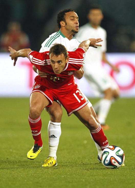 Issam Erraki of Morocco's Raja Casablanca fights for the ball with Rafinha of Germany's Bayern Munich during their 2013 FIFA Club World Cup final soccer match at Marrakech stadium