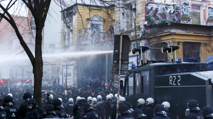 German police use water cannons to clear a street following clashes in front of the 'Rote Flora' cultural centre during a demonstration in Hamburg