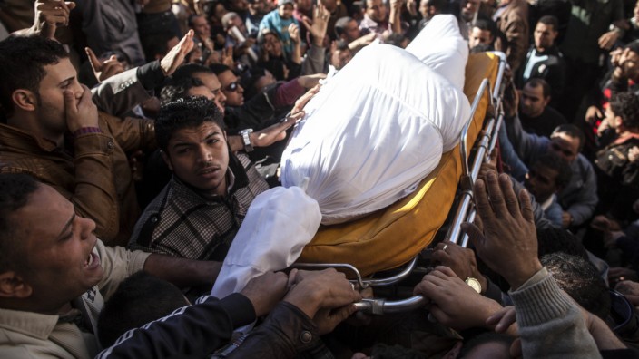 Ägypten: Anschlag in Mansura: Ägypter tragen während der Beerdigung einen der 16 Toten des Anschlags durch die Menge.
