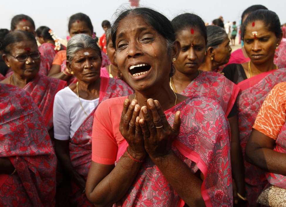 A woman cries during a prayer ceremony for the victims of the tsunami on the ninth anniversary of the disaster, at Marina beach in Chennai