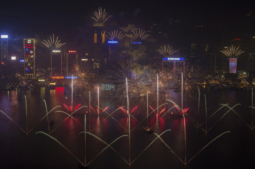 Fireworks explode over Victoria Harbour and Hong Kong Convention and Exhibition Centre  during a pyrotechnic show to celebrate the New Year in Hong Kong