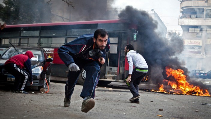 Unruhen vor Mursi-Prozess: Mursi-Anhänger gehen vor Tränengas-Granaten in Deckung.