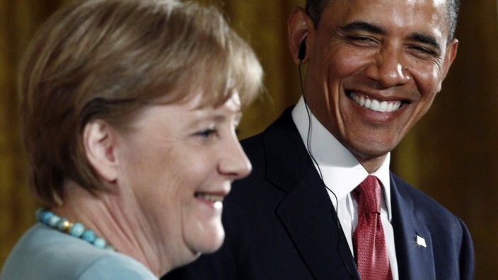 U.S. President Obama smiles at Germany's Chancellor Merkel as she speaks during a joint press availability at the White House in  Washington