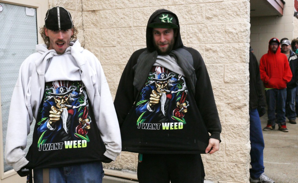 Mark Gordon and Ryan Perry display their 'I Want Weed' t-shirts as they wait in line to be among the first to legally buy recreational marijuana at the Botana Care store in Northglenn