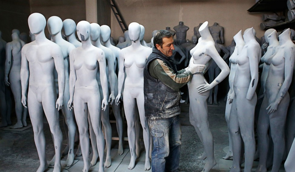 A worker carries a mannequin at a factory of Koray Vitrin Mankenleri in Ankara