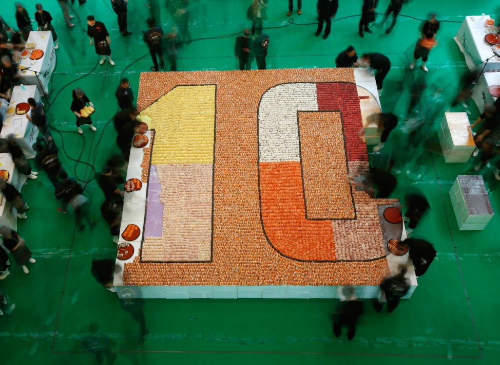 Participants arrange sushi to create mosaic during 10th anniversary of a sushi chain store in Hong Kong