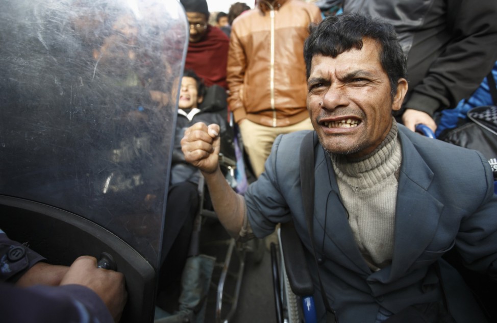 A disabled man tries to break the police line during a sit-in protest organized by people with different disabilities outside Singha Durbar office complex in Kathmandu