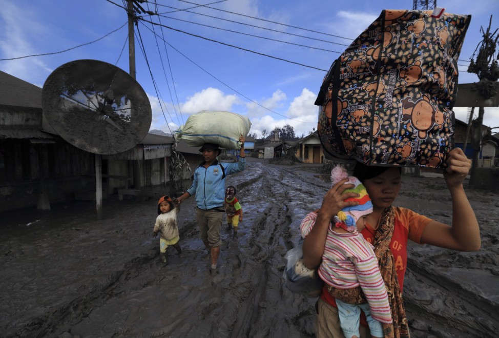 A family is evacuated to safety after Mount Sinabung erupted at Kuta Rakyat village in Karo district