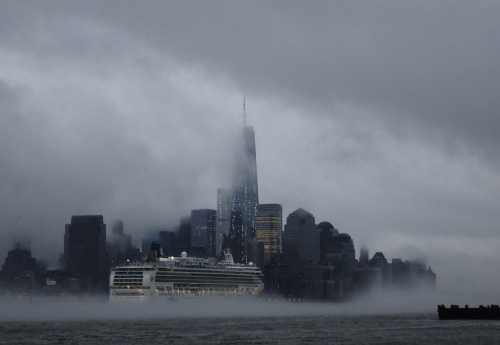 A cruise ship makes its way past  New York's Lower Manhattan and One World Trade Center as steam rises from the Hudson River as seen from Hoboken, New Jersey