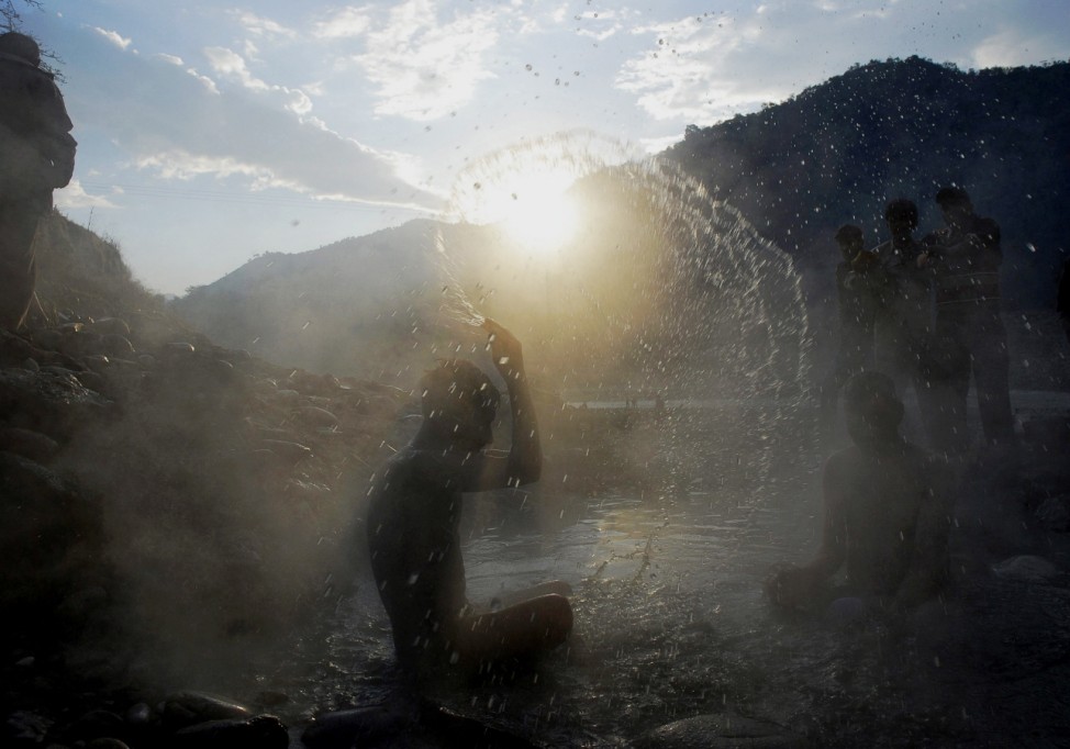 A Hindu devotee bathes in natural hot spring water on the banks of the Satluj river on the occasion of the Makar Sankranti festival at Tattapani in Himachal Pradesh