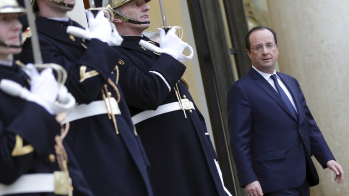 French President Hollande stands on the stairs of the entrance of the Elysee Palace in Paris after a meeting