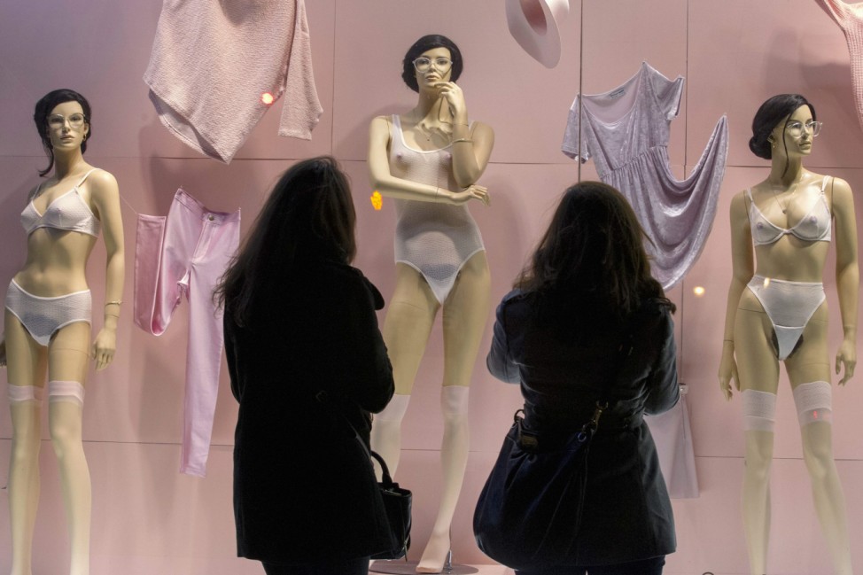 Women look at anatomically correct female mannequins displayed at the American Apparel store in SoHo, New York