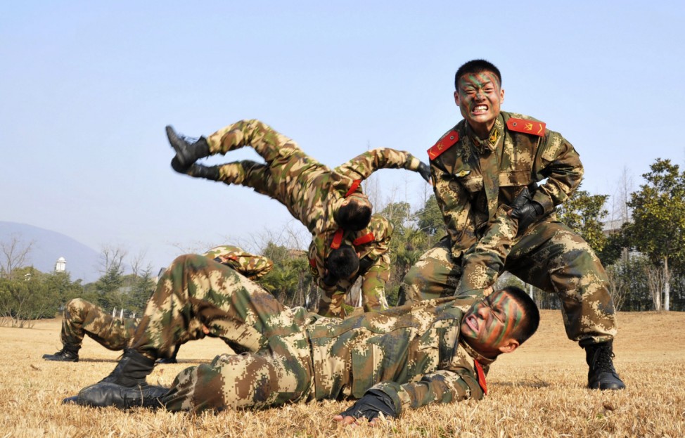 Paramilitary policemen wrestle as they take part in a winter training session at a military base in Chaohu