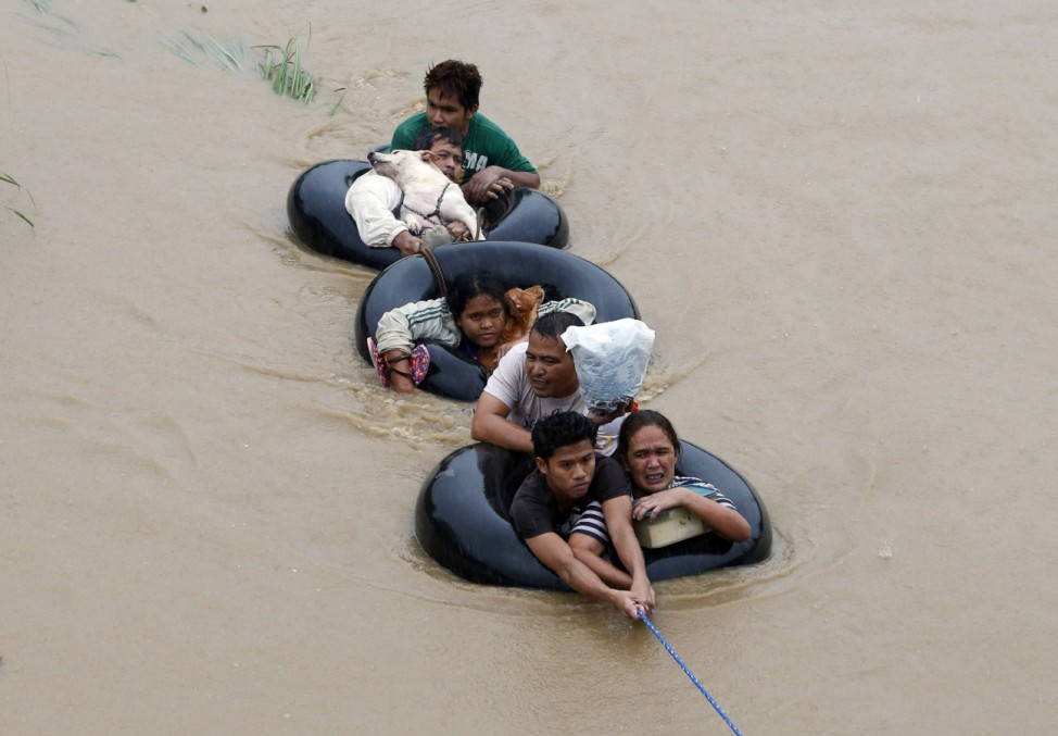Flood victims are pulled on inflatable tire tubes as they are evacuated from heavy flooding brought by tropical depression 'Agaton', in Butuan