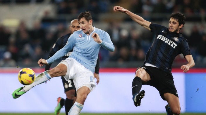 Lazio's Klose shoots to score as he is challenged by Inter Milan's Ranocchia during their Italian Serie A soccer match at the Olympic stadium in Rome
