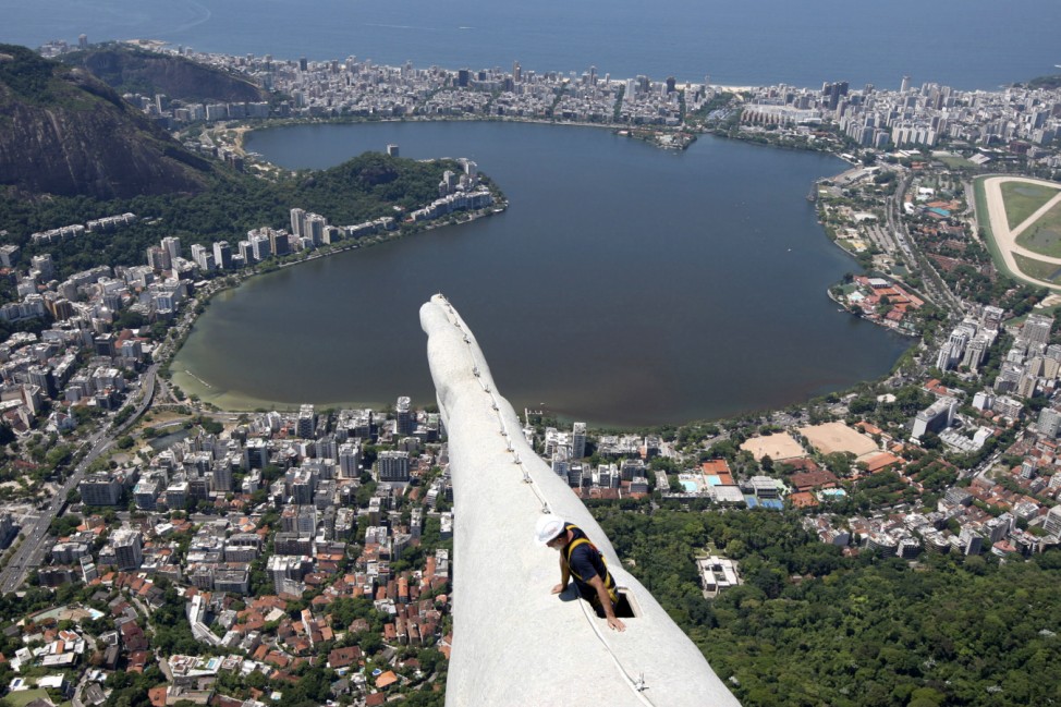 A worker inspects the Christ the Redeemer statue which was damaged during lightning storms in Rio de Janeiro