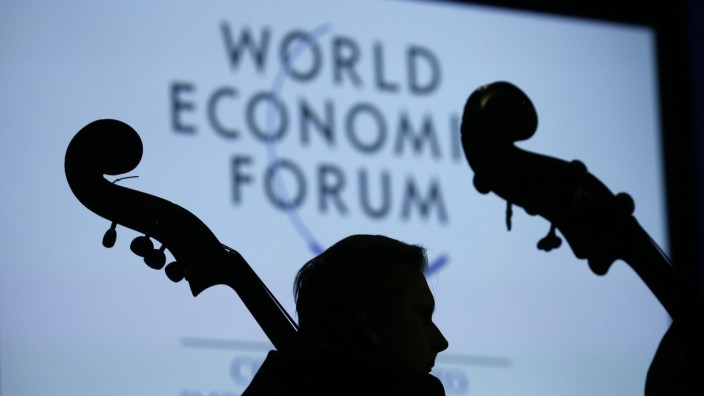 A musician is silhouetted as he listens during the Crystal Awards Ceremony at the annual meeting of the WEF in Davos