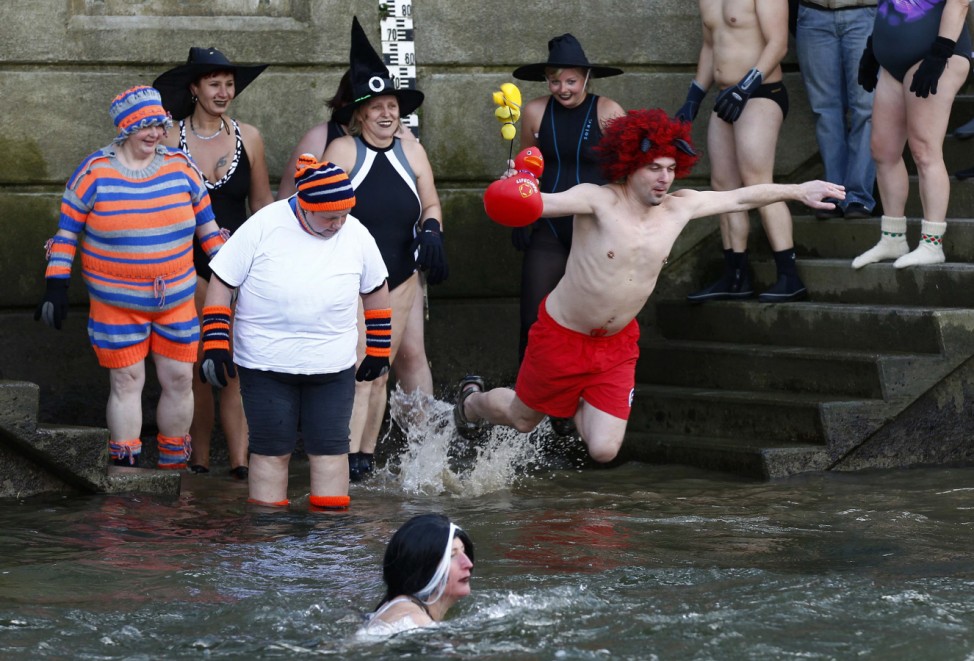 Swimmers jump into the cold waters of the river Danube in Neuburg an der Donau