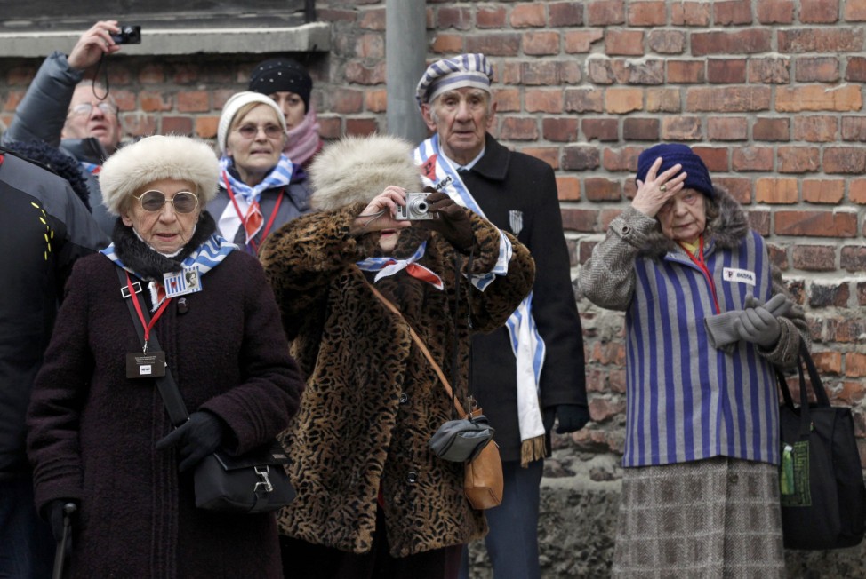Holocaust survivors stand in front of the Death Wall during during a ceremony to mark the 69th anniversary of the liberation of Auschwitz concentration camp and to remember the victims of the Holocaust in Auschwitz