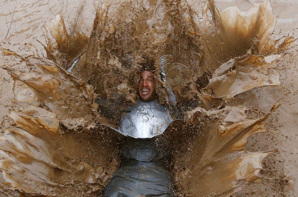Competitor falls into muddy water during the Tough Guy event in Perton