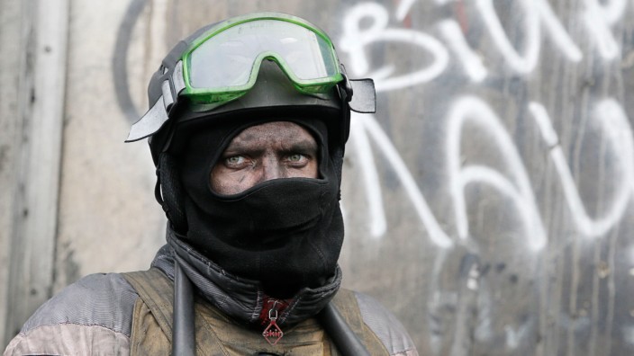 Proteste in der Ukraine: Ein vermummter Demonstrant bewacht eine Barrikade in Kiew