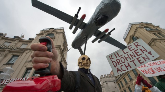 Ein als Tod verkleideter Mann mit einer Drohne über dem Kopf und einem roten Steuerhebel in der Hand nimmt am 02.02.2013 an einer Demonstration gegen die 49. Münchner Sicherheitskonferenz in der Innen